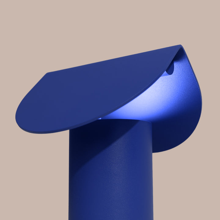 Lampe à poser BISCUIT outremer allumée, vue de trois quarts