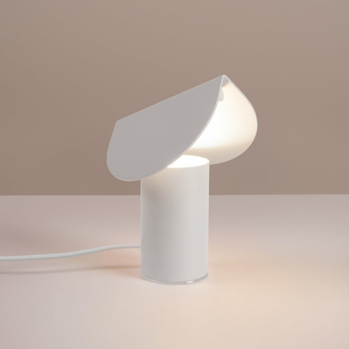 Lampe à poser BISCUIT blanc allumée, sur une table