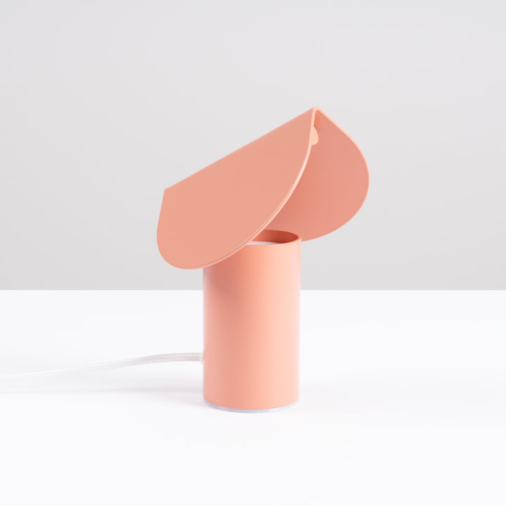 Lampe à poser BISCUIT pêche éteinte, sur une table
