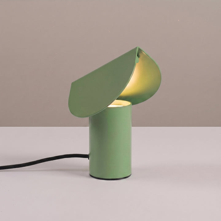 Lampe à poser BISCUIT sauge allumée, sur une table