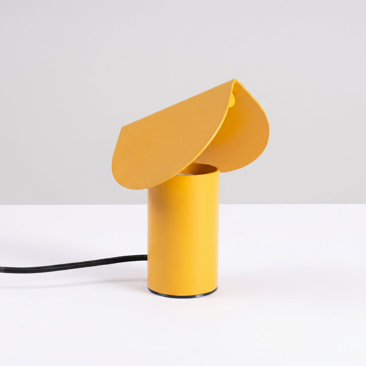Lampe à poser BISCUIT jaune éteinte, sur une table