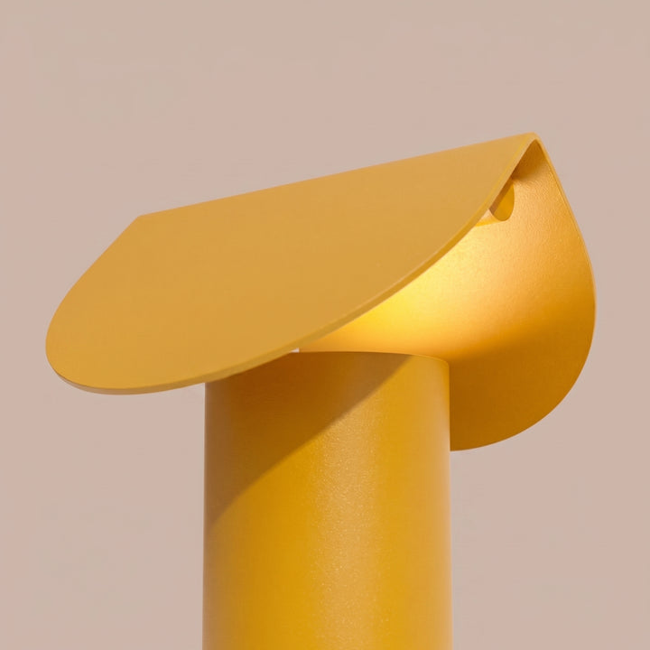Lampe à poser BISCUIT jaune allumée, vue de trois quarts