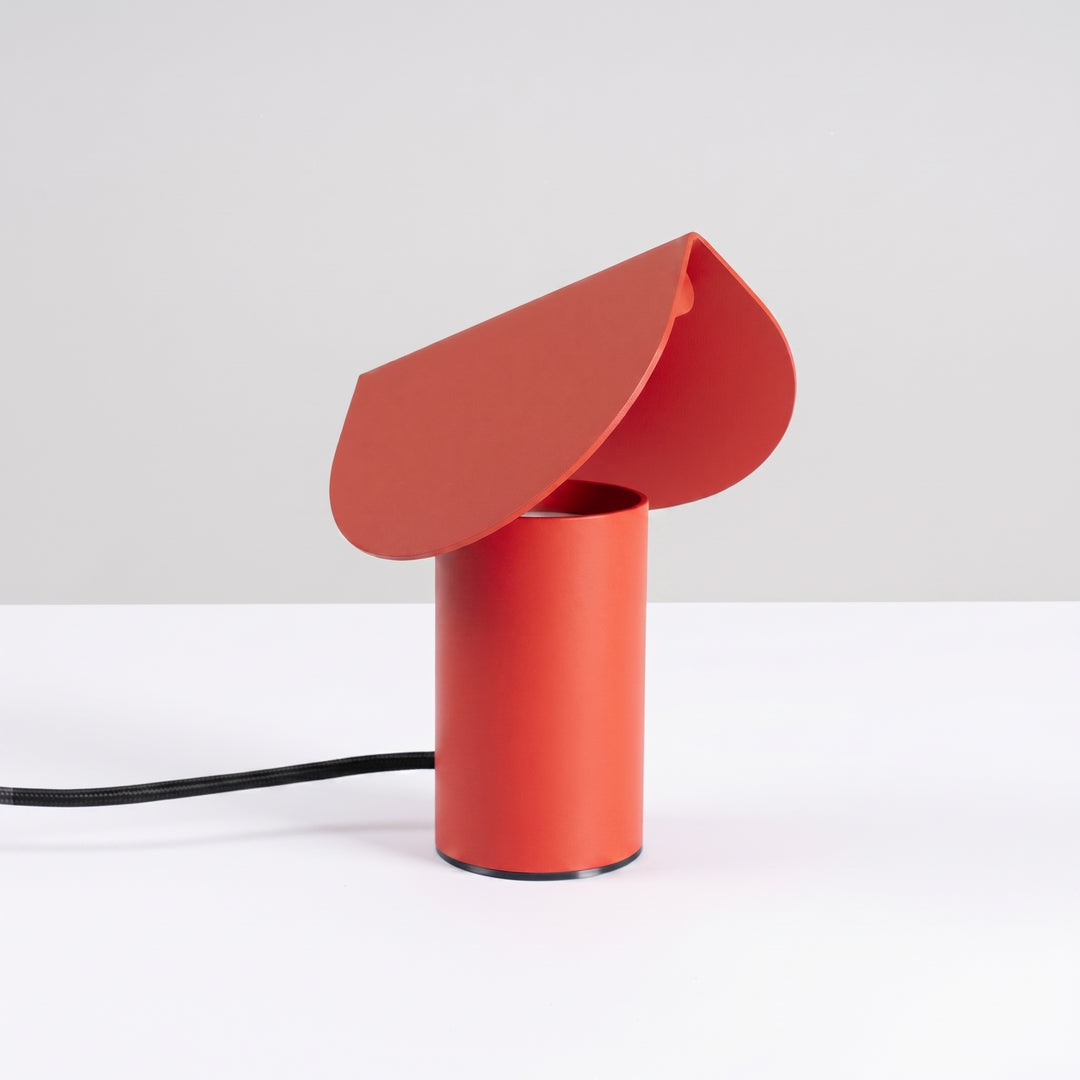 Lampe à poser BISCUIT rouge éteinte, sur une table