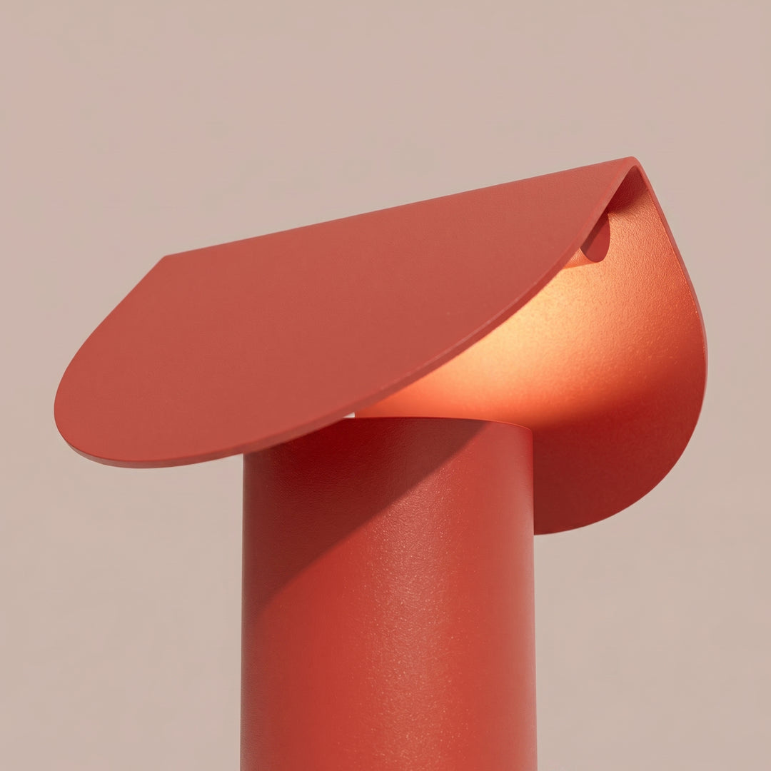 Lampe à poser BISCUIT rouge allumée, vue de trois quarts