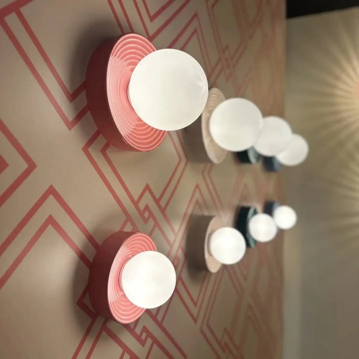 Applique murale alicia en sphère rose et blanche avec motifs circulaires concentriques sur la base