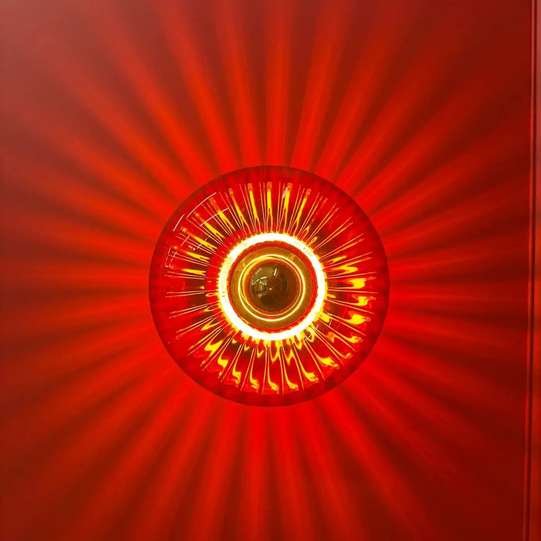 L’applique grace en verre soufflé rouge avec un motif soleil rayonnant pour un éclairage mural élégant