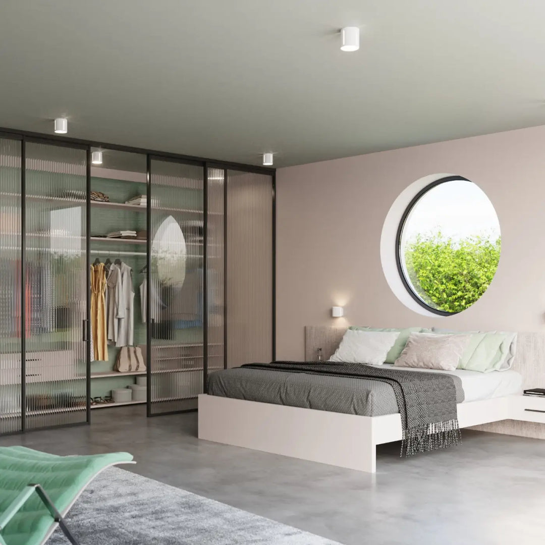 Lit plateforme moderne blanc avec literie grise et coussins verts pour l’applique murale inez perforation linéaire