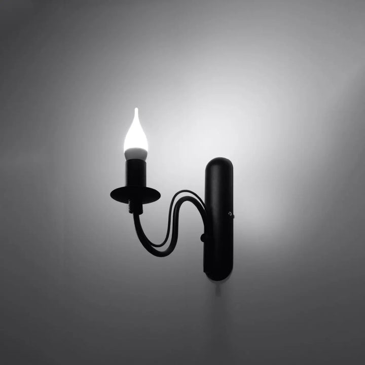 Applique bougeoir noir en fer forgé avec une ampoule bougie allumée style glamour pour décoration intérieure