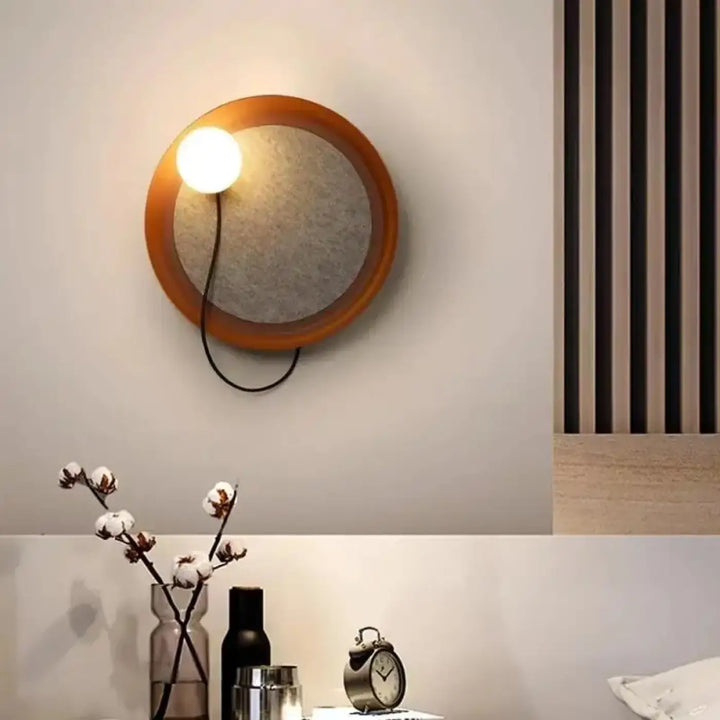 Applique murale contemporaine warm-toned avec cadre en bois et centre texturé gris avec ampoule visible orluna
