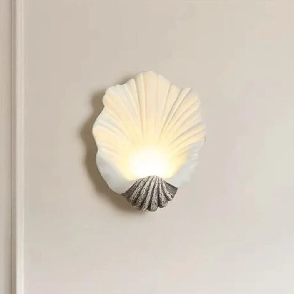 Applique murale TIAUIA coquillage off-white avec base grise texturée éclaire chaleureusement