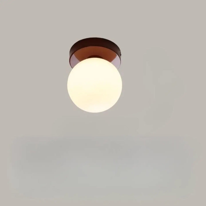 Applique murale puffo avec globe en verre chaud et base en métal bronze pour un abat-jours arrondis design doux