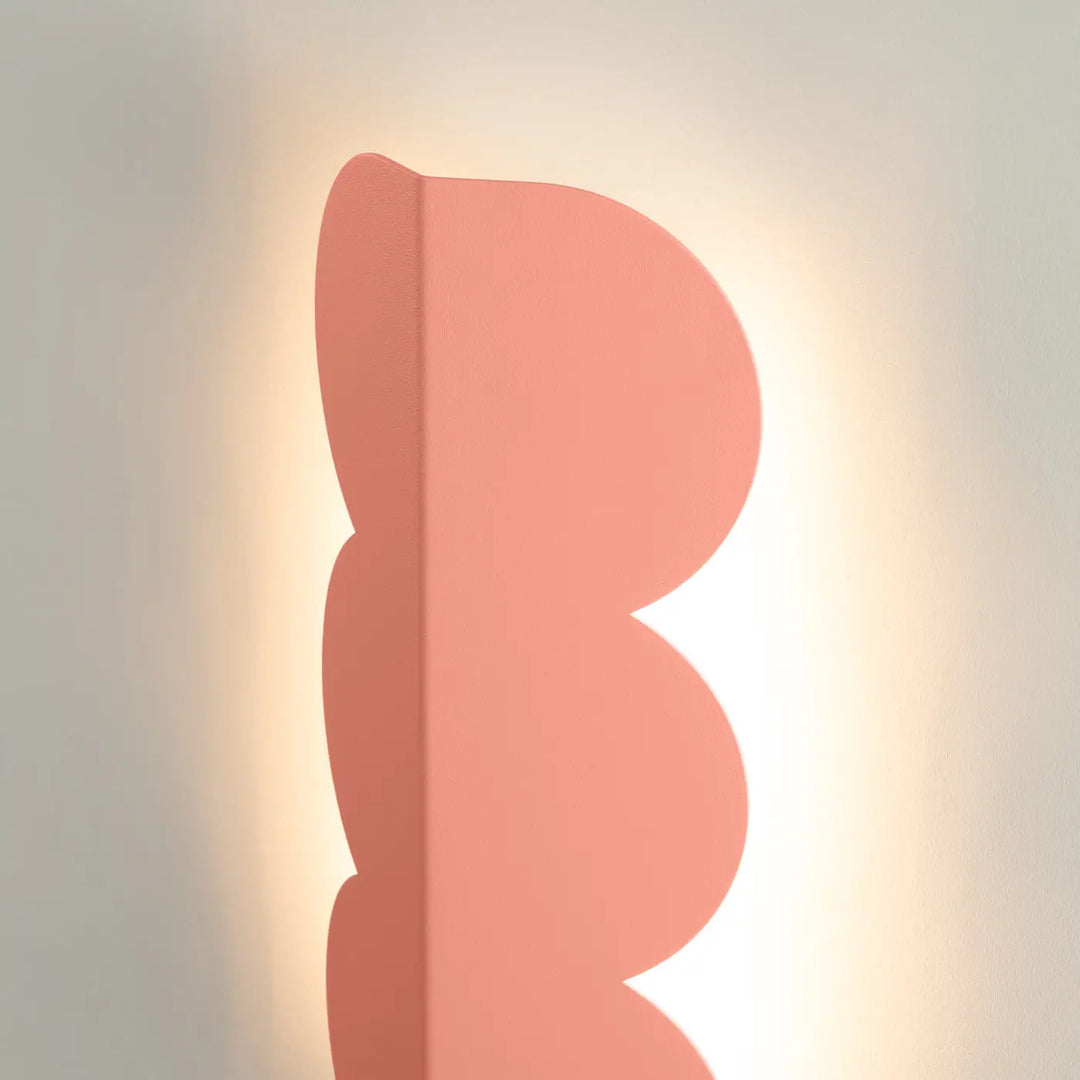 Applique murale biscuit peach compose d’une lampe avec forme ondulée caractéristique en corail doux