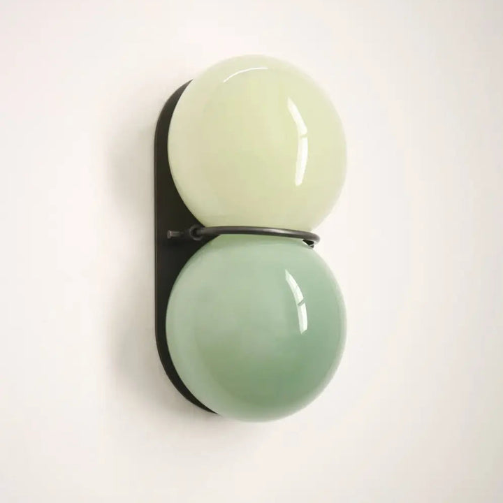 Applique murale gemini avec double boule en verre crème et vert menthe sur cadre métal noir pour décoration intérieure moderne