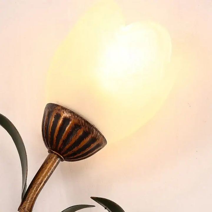 Applique murale florale dorée avec globe en verre blanc chic