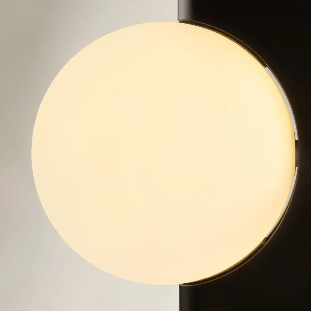 Applique murale avant garde avec monture géométrique noire mate et diffuseur en verre opale lumineux chaud