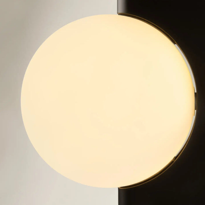Applique murale avant garde avec monture géométrique noire mate et diffuseur en verre opale lumineux chaud