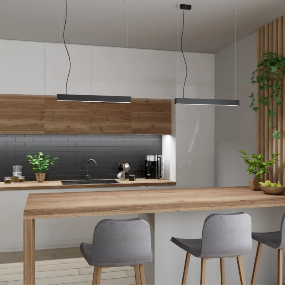 Lampe suspendue noire linéaire de la collection pinne avec paramètres d’éclairage 4000k au-dessus d’un îlot en bois