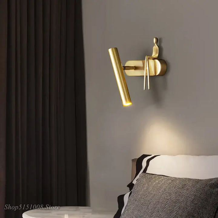 Applique murale LED noir avec un bonhomme doré assis

