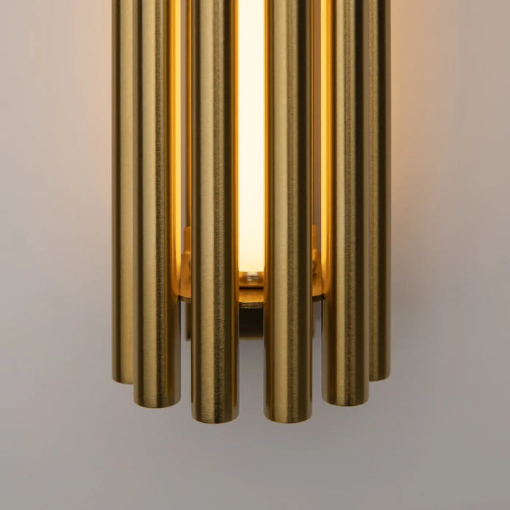 Applique murale led sonata cylindre en métal doré avec tubes verticaux éclairant une lumière chaude et diffuse