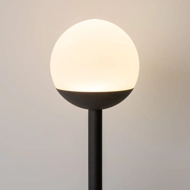 Applique murale led cercle lumineux noir avec globe en verre givré émettant une lumière douce et chaude