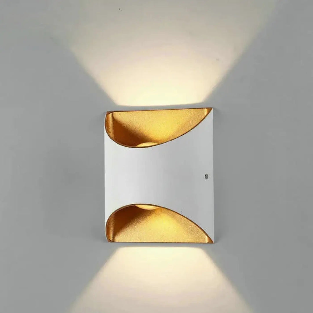 Applique murale moderne deux lumières blanche et or avec découpes courbes diffusant une lumière chaude extérieure