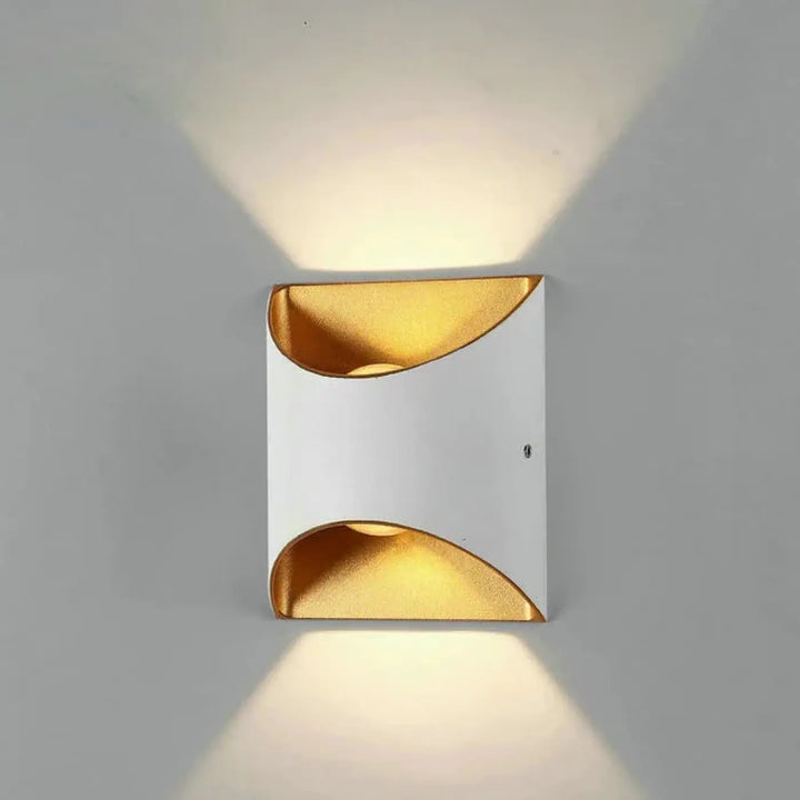 Applique murale moderne deux lumières blanche et or avec découpes courbes diffusant une lumière chaude extérieure