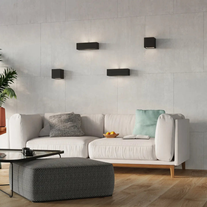 Applique murale moderne en céramique leo noire avec design minimaliste et belle lumière sur mur texturé gris clair