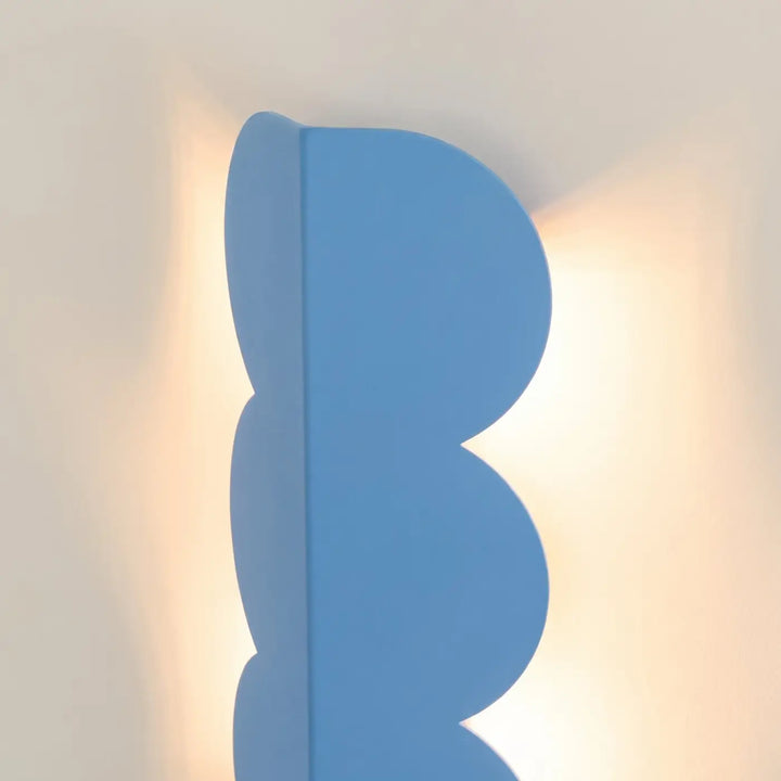 Applique murale BISCUIT bleu clair allumée, vue de profil