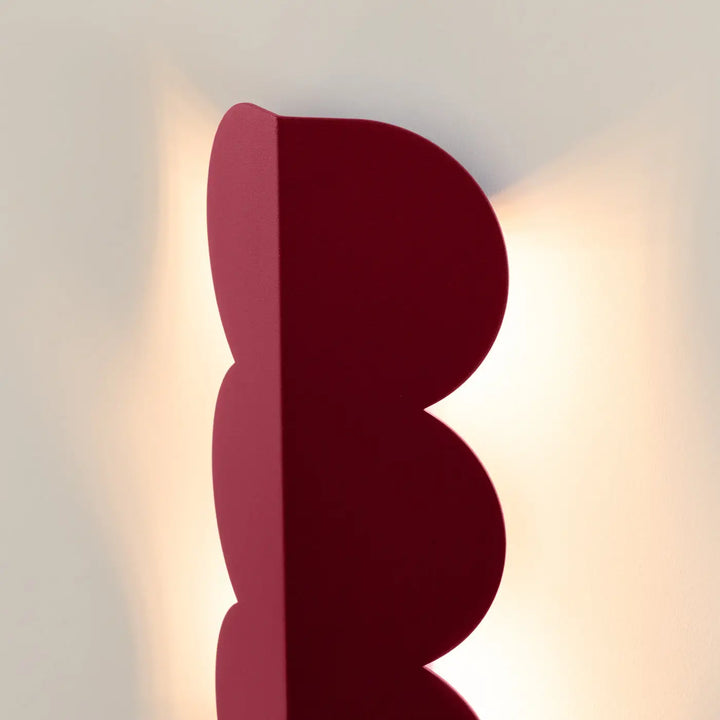 Applique murale BISCUIT bordeaux allumée, vue de profil