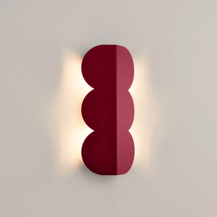Applique murale BISCUIT bordeaux allumée, halo sur le mur
