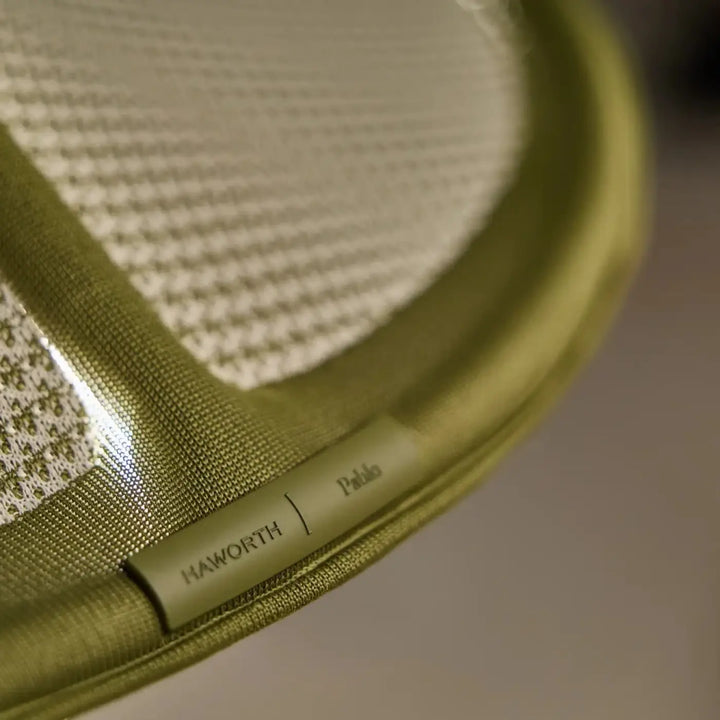 Olive green woven fabric tennis racket with textured grip and haworth paolo branding for applique murale pantaya by patricia urquiola tricot tendu