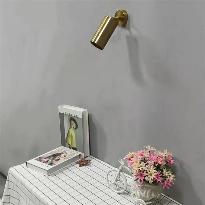 Applique murale cylia en métal doré de forme cylindrique avec un design moderne et épuré pour un éclairage ciblé