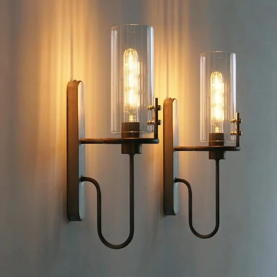 Applique murale industriale en metal bronze fonce avec deux cylindres en verre transparent et ampoules a filament visible