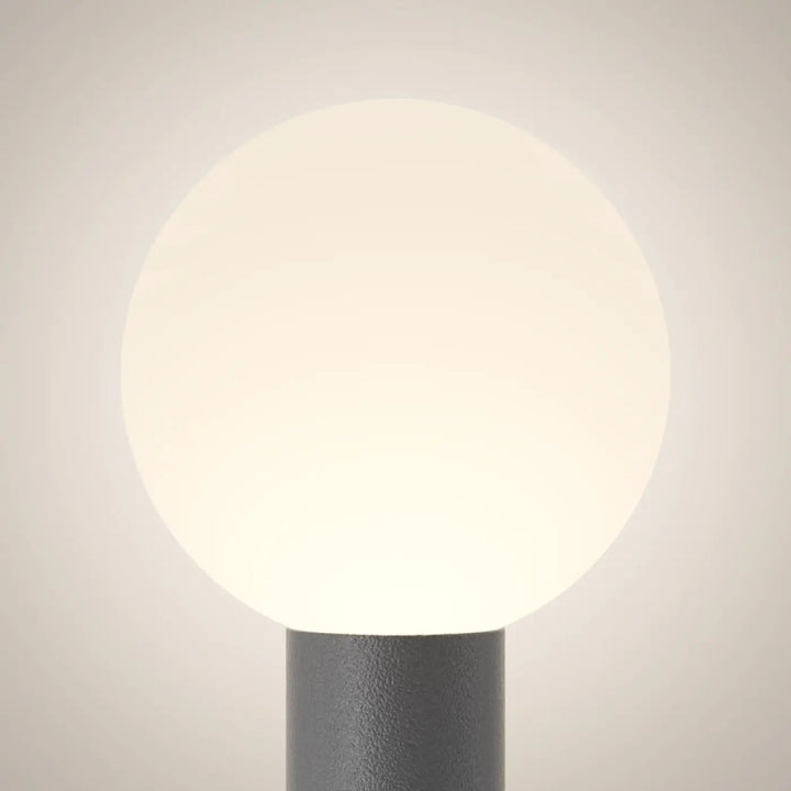 Borne extérieure bold globe opale avec lumière douce et globe blanc opalescent sur poteau gris mat