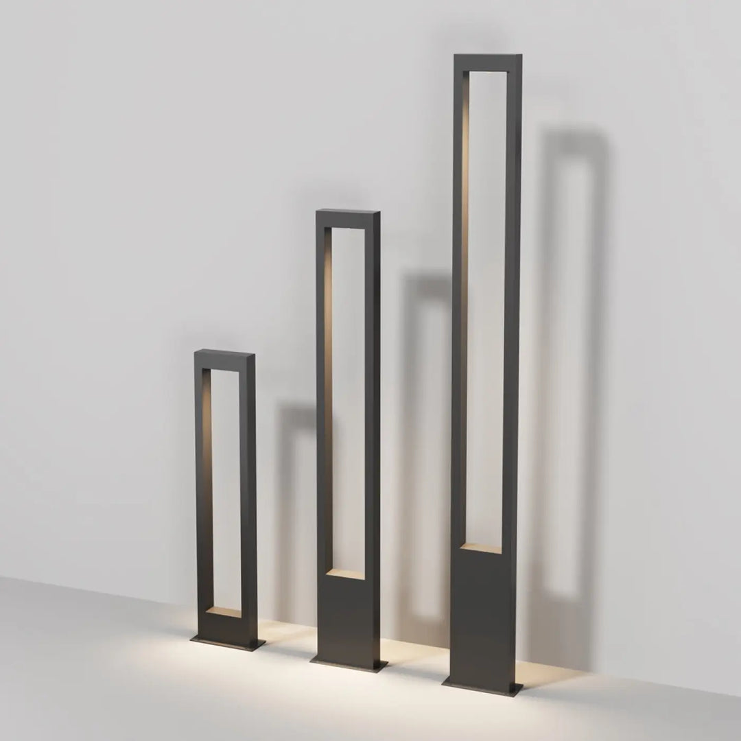 Trois bornes extérieures arche rectangulaires en métal graphite avec éclairage intérieur chaleureux et design minimaliste