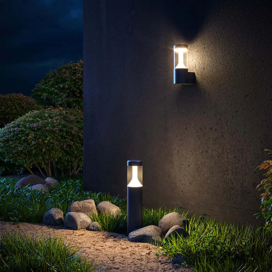 Borne extérieure cylindrique en acier noir avec lumière claire chaude pour usage extérieur moderne