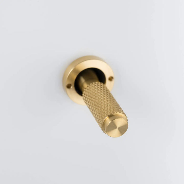 Détail d'un levier à gravure quadrillée, finitions blanc et laiton #couleur_dor