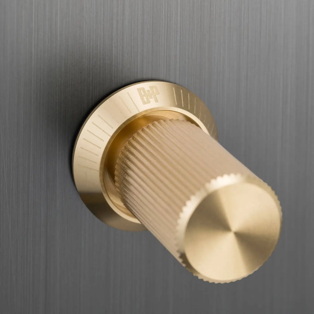 Détail d'un variateur à gravure alignée, finitions bronze fumé et laiton #couleur_dor