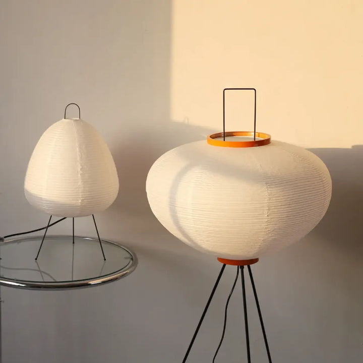 Lampadaire siriah en papier blanc avec base tripode métallique noire et bord en bois orange design moderne élégant