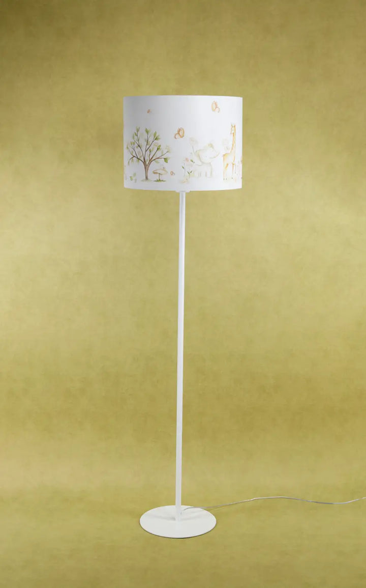 Lampadaire enfant blanc avec abat-jour cylindrique en carton marron clair à découpes nature participe à créer une ambiance douce