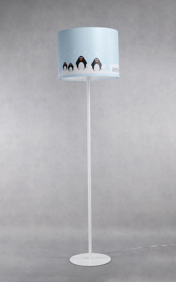 Lampadaire enfant blanc bleu pastel avec abat-jour cylindrique illustré de pingouins noir et blanc sur pied métal blanc