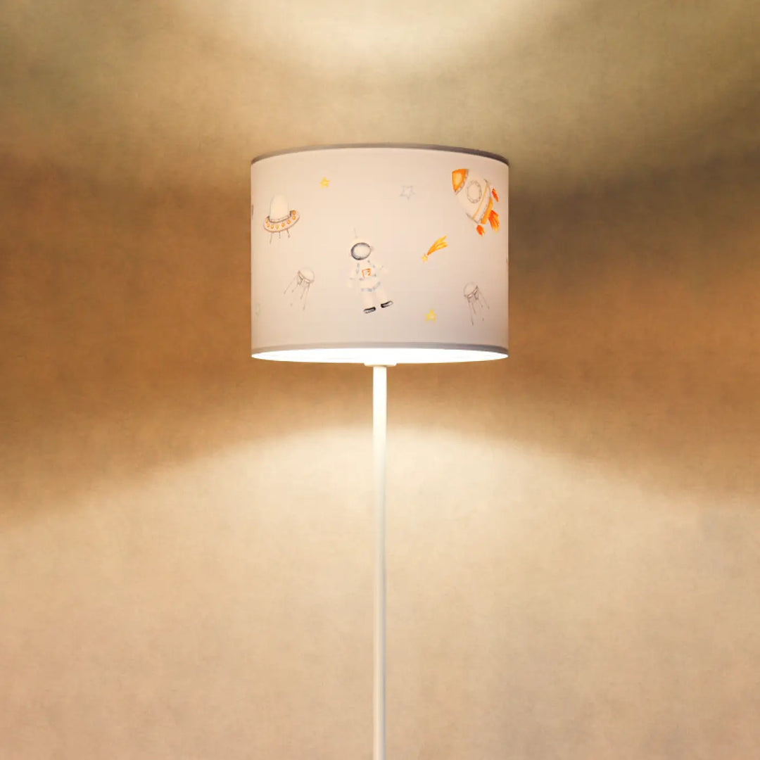 Lampadaire enfant bleu pastel avec abat-jour blanc cylindrique illustré aux aventures spatiales doux orange jaune gris