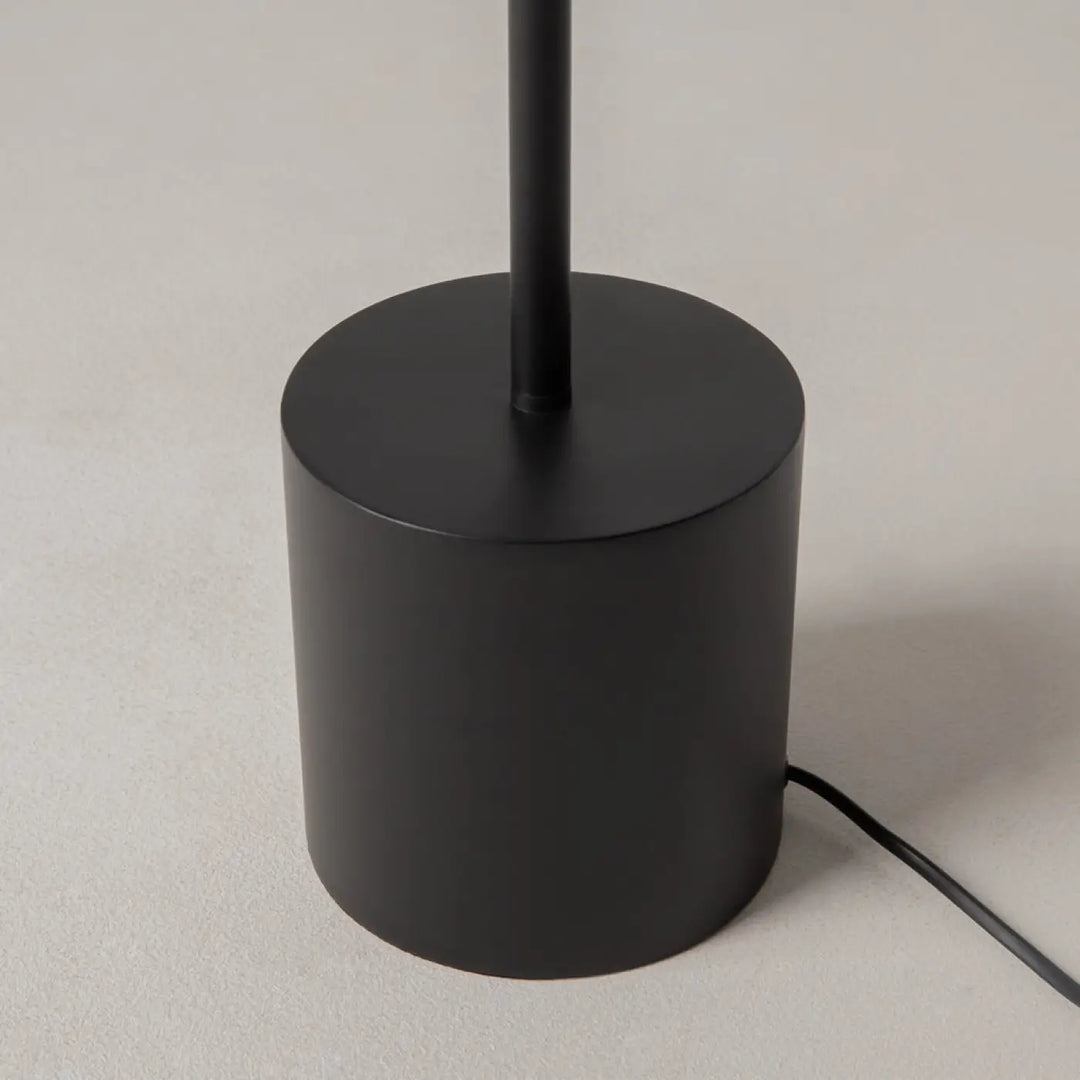Lampadaire evolution avec base cylindrique en aluminium noir mat et tige fine pour une lumière douce intérieure
