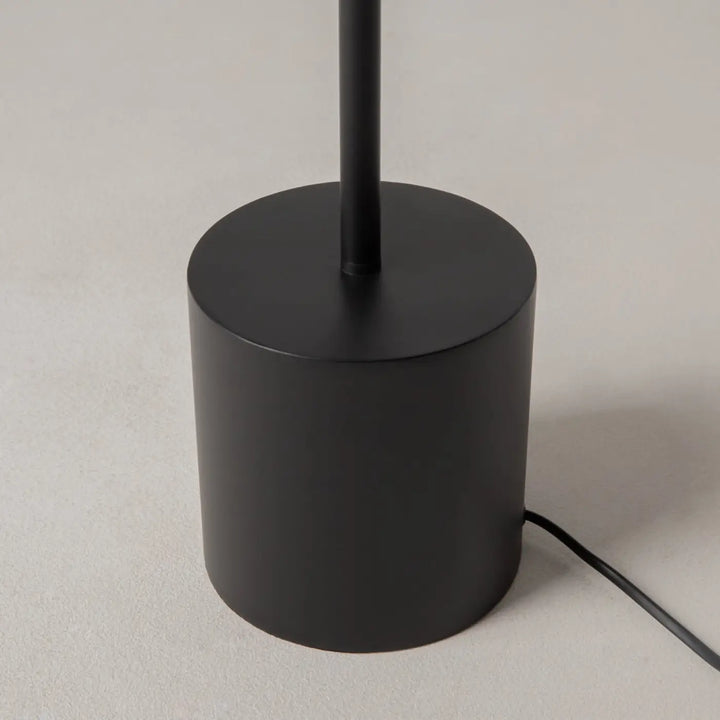 Lampadaire evolution avec base cylindrique en aluminium noir mat et tige fine pour une lumière douce intérieure