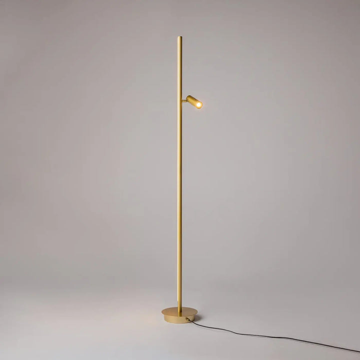 Lampadaire thin doré avec poteau fin vertical et spot led ajustable idéal d’un canapé moderne