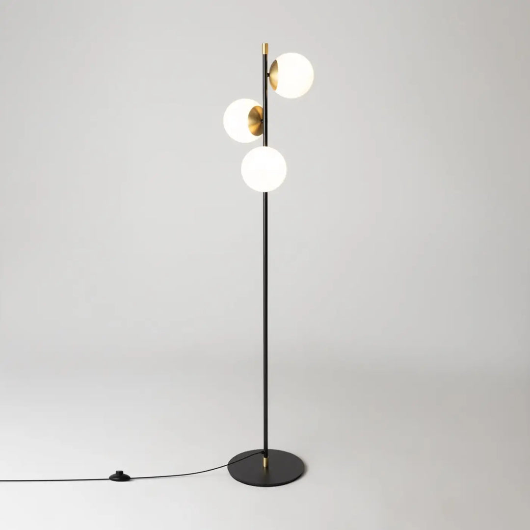Modern lampadaire trois globes en acier noir avec abat-jours en verre opalin et finitions dorées élégantes