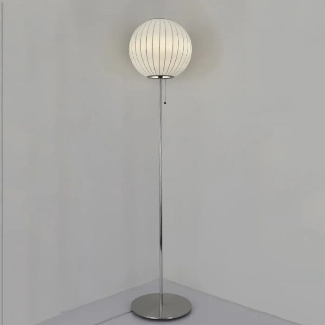 Lampadaire monna avec globe lumineux blanc nervuré et pied chrome pour une décoration intérieure style nordique