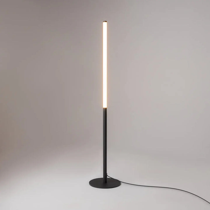 Minimalist lampadaire ray en acier noir avec tube lumineux led cylindrique émettant une lumière blanche chaude