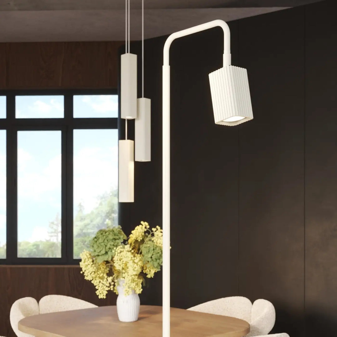 Lampadaire Rayo beige à spot rainuré près d'une table à manger