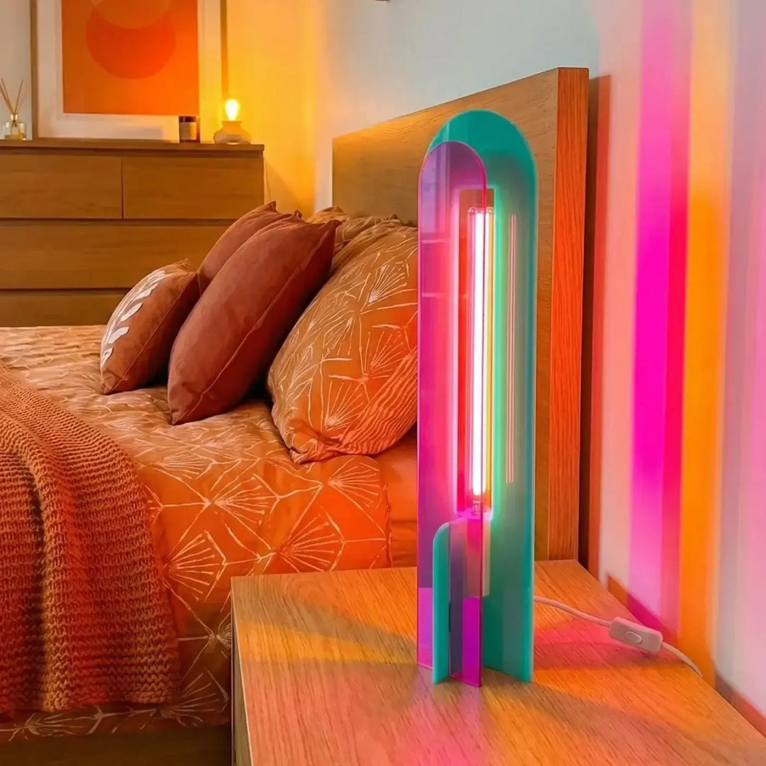 Lampe de chevet andy en acrylique coloré teal et violet néon avec tube vertical style pop art sur table de nuit en bois